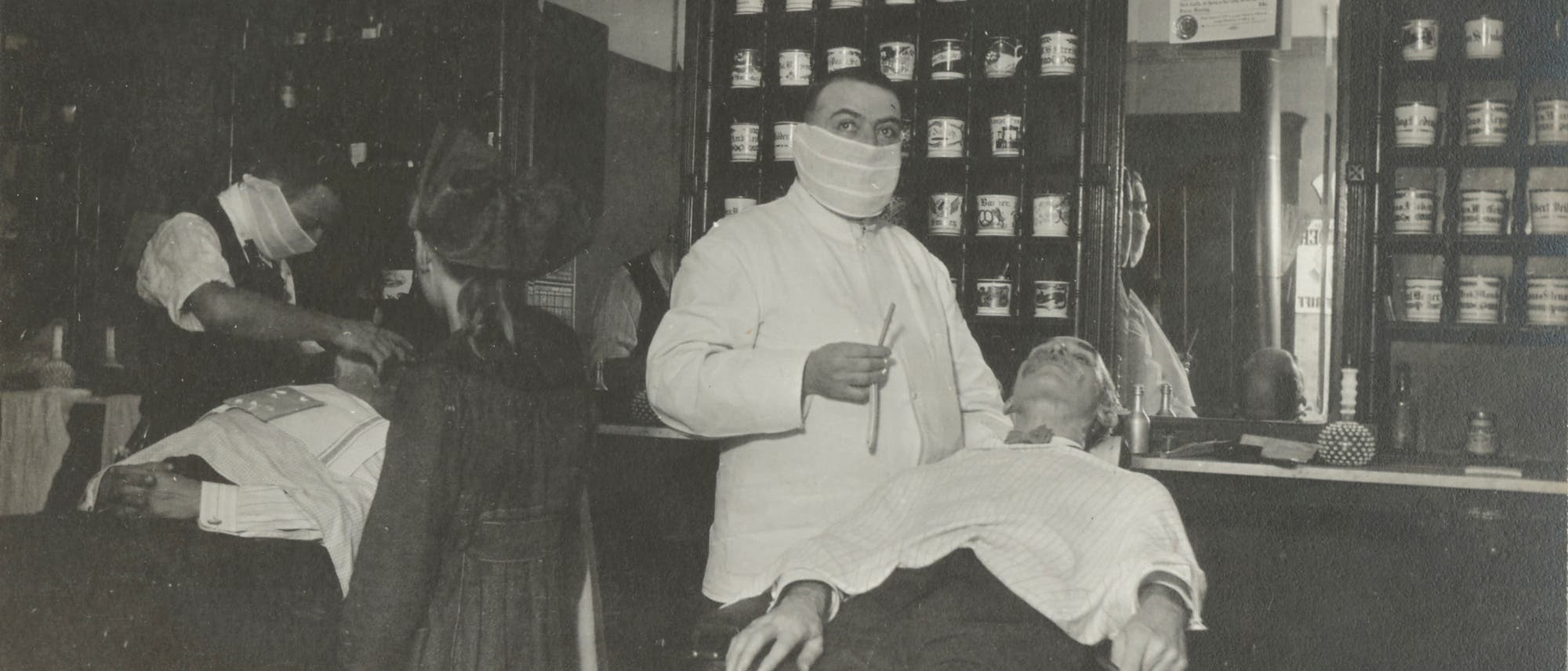 Barbiere und Frisöre mit Mund-Nase-Bedeckung während der Spanischen Grippe 1918 Barbiere und Frisöre mit Mund-Nase-Bedeckung während der Spanischen Grippe 1918