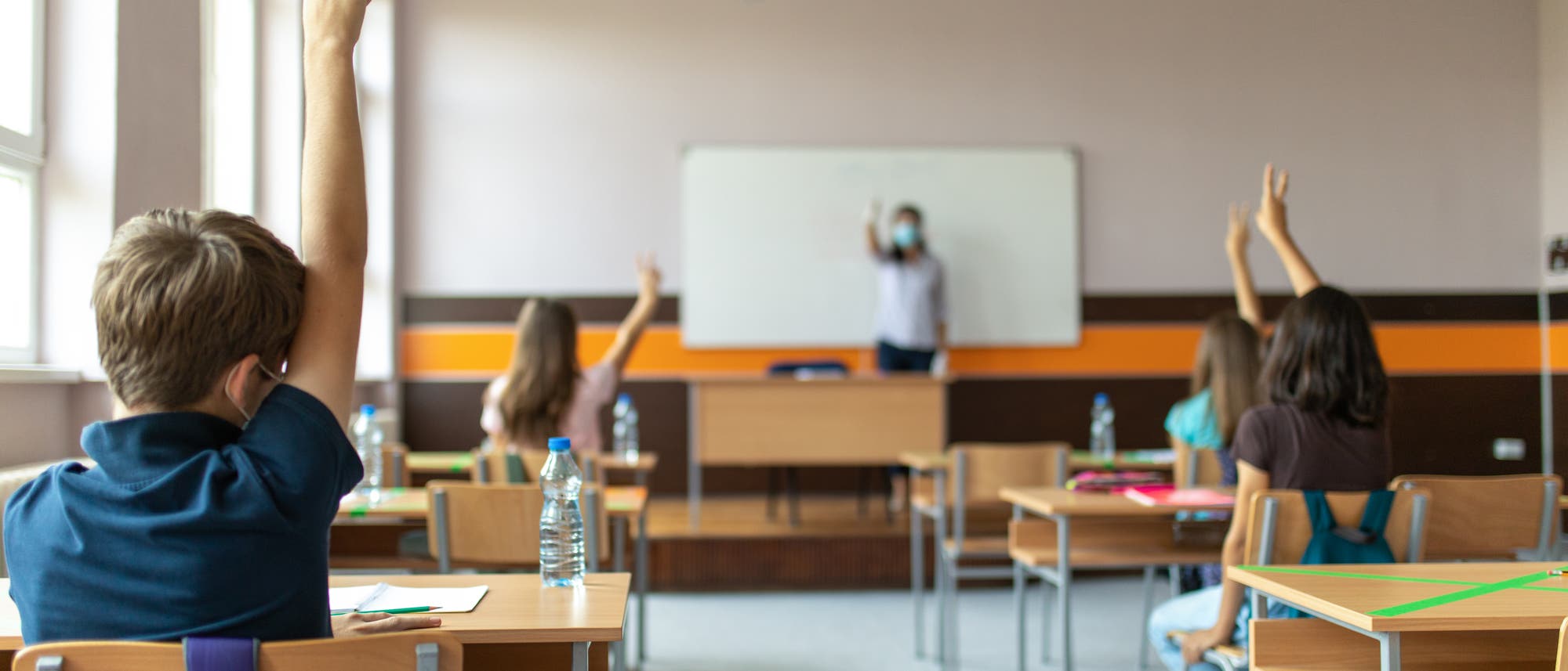 Schüler lernen mit Abstand und Masken im Klassenzimmer Schüler lernen mit Abstand und Masken im Klassenzimmer