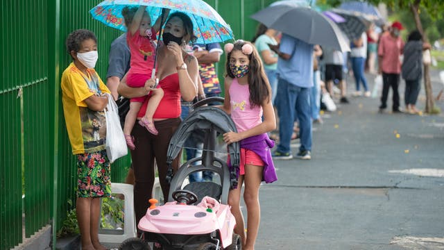Menschen warten im Februar 2021 in Brasliens Stadt Serrana, Sao Paulo, vor einer öffentlichen Schule, um eine Impfung mit dem Sinovac CoronaVac-Impfstoff zu bekommen. 