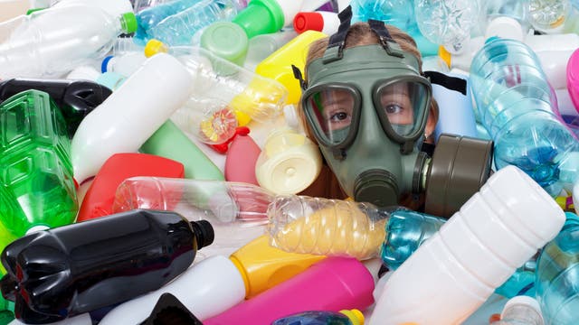 Kind mit Gasmaske zwischen Plastikflaschen - ich hoffe, das ist kein Fetisch