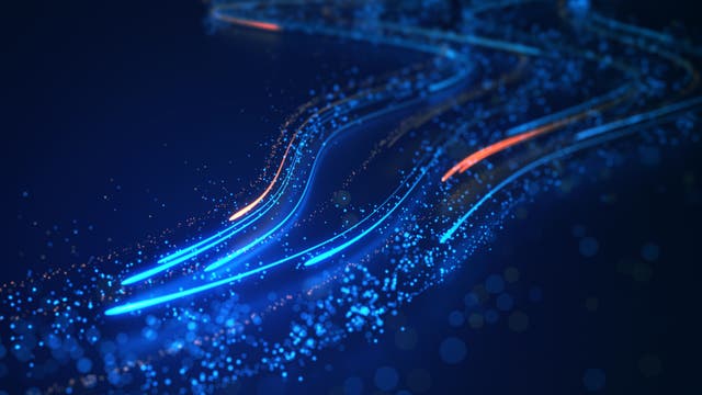 Abstrakte Darstellung von Datenströmen in einem digitalen Netzwerk. Leuchtende blaue und orangefarbene Linien schlängeln sich durch einen dunklen Hintergrund, gesprenkelt mit kleinen, funkelnden Punkten, die den Fluss von Informationen symbolisieren. Die geschwungenen Linien erzeugen ein Gefühl von Bewegung und Konnektivität, das die Dynamik moderner Technologie und Kommunikation widerspiegelt.