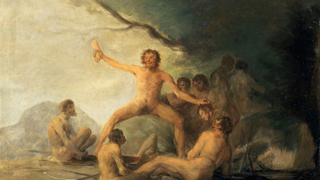 Zu sehen ist ein Gemälde von Francisco Goya, das Kannibalen darstellen soll. Eine Gruppe von nackten Menschen sitzt und steht in einer Höhle. Eine zentrale Figur hält in erhobener Hand eine menschliche Hand. Die Szene ist in dunklen, erdigen Tönen gehalten, was eine düstere und mystische Atmosphäre schafft. Im Hintergrund sind weitere Figuren schemenhaft zu erkennen. 