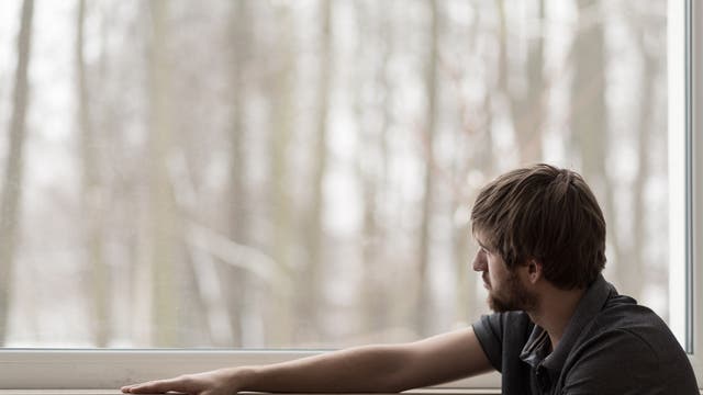 Depressiv blickender Mann am Fenster
