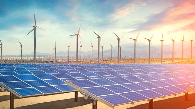 Im Vordergrund Solarpaneele, im Hintergrund Windräder, drumherum eine Landschaft, die ganz klar arid wirkt.
