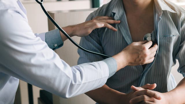 Arzt hört das Herz eines Patienten ab