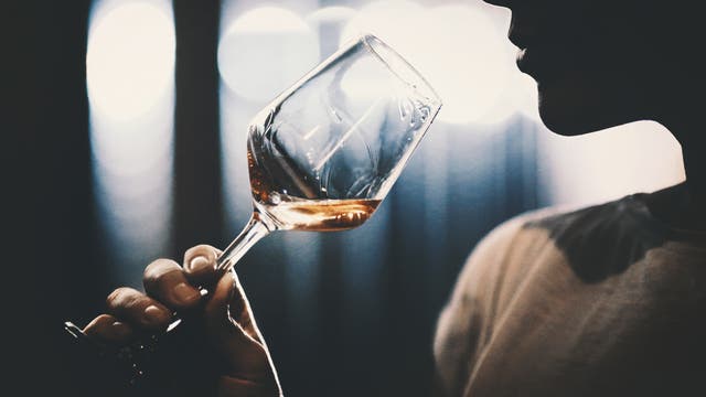Schemenhafte Frau hält ein Glas Wein