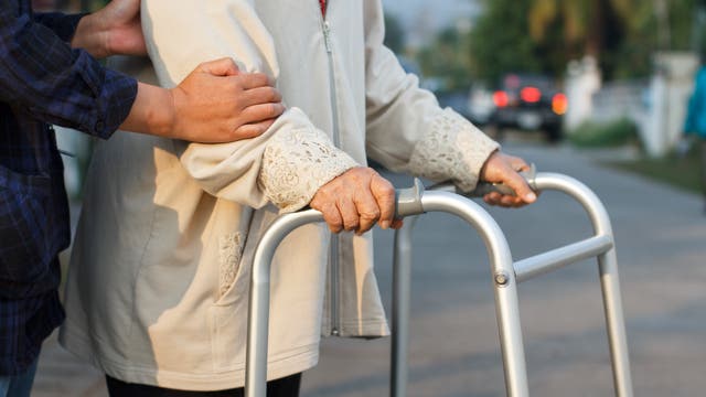 Frau hilft älterer Frau über die Straße