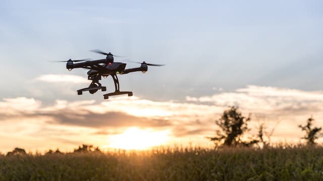 Eine Drohne des Typs Typhoon Q500 fliegt in den Sonnenuntergang.