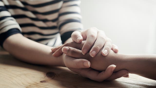 Eine Frau hält die Hand einer anderen.