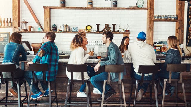 Menschen sitzen an einer Bar und unterhalten sich
