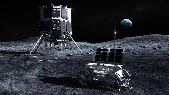Ein Mondrover mit vier Rädern und Solarpanelen steht auf der Mondoberfläche. Im Vordergrund ist ein größerer Lander mit mehreren Logos, darunter "SMBC" und "JINS", zu sehen. Die Erde ist am Horizont sichtbar. Die Szene vermittelt eine futuristische Mondmission.