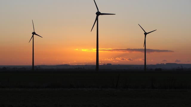 Drei Windräder in der Abenddämmerung